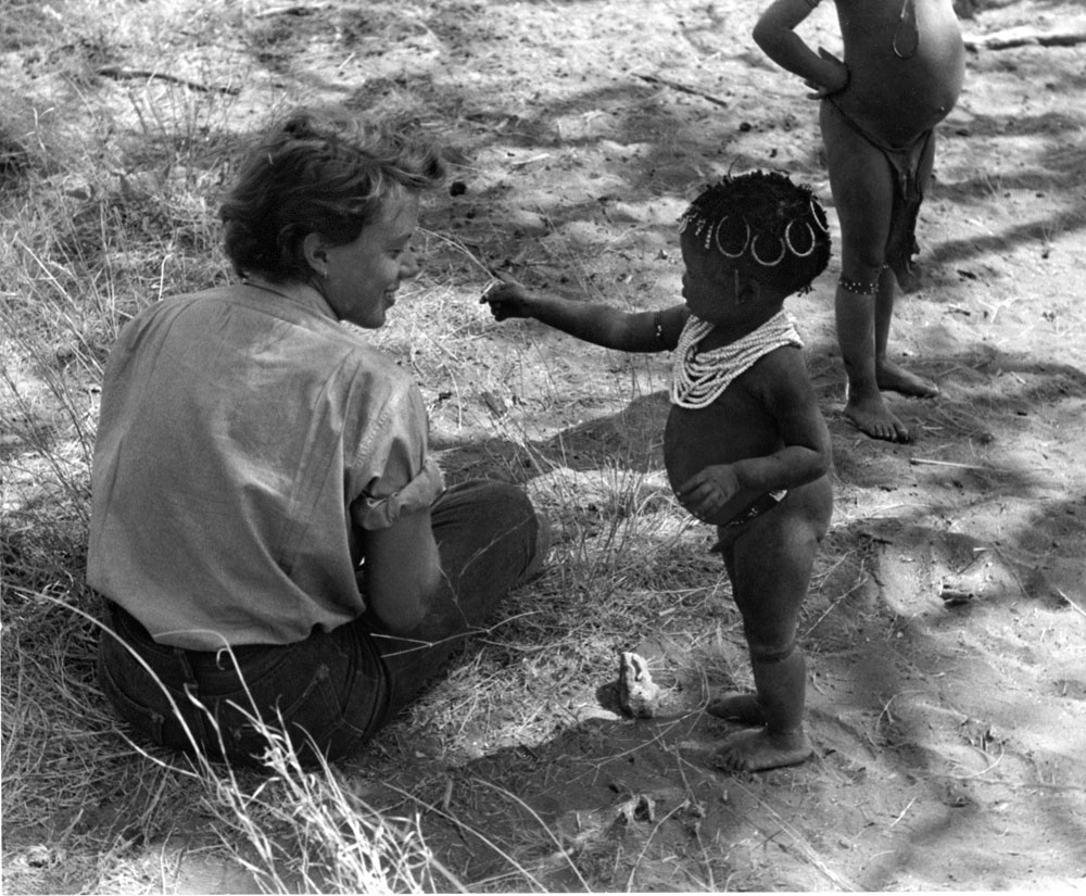 Elizabeth, being offered a caterpillar from San/Bushman child